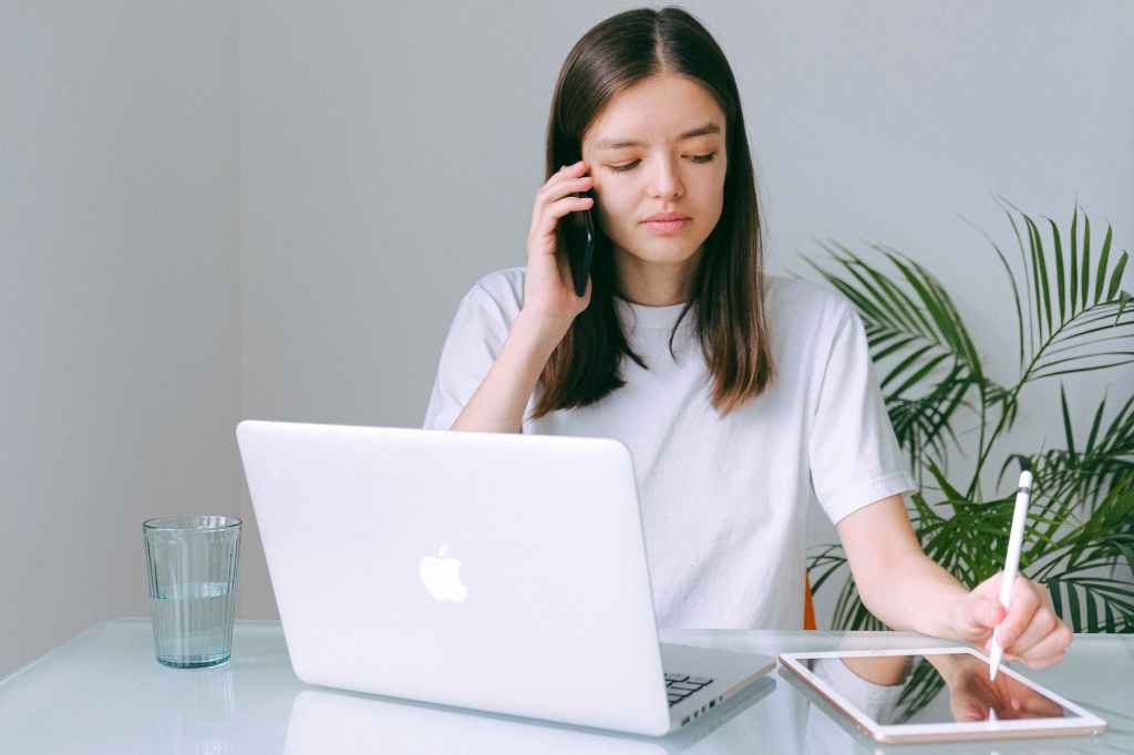 woman in white crew neck t shirt using silver macbook